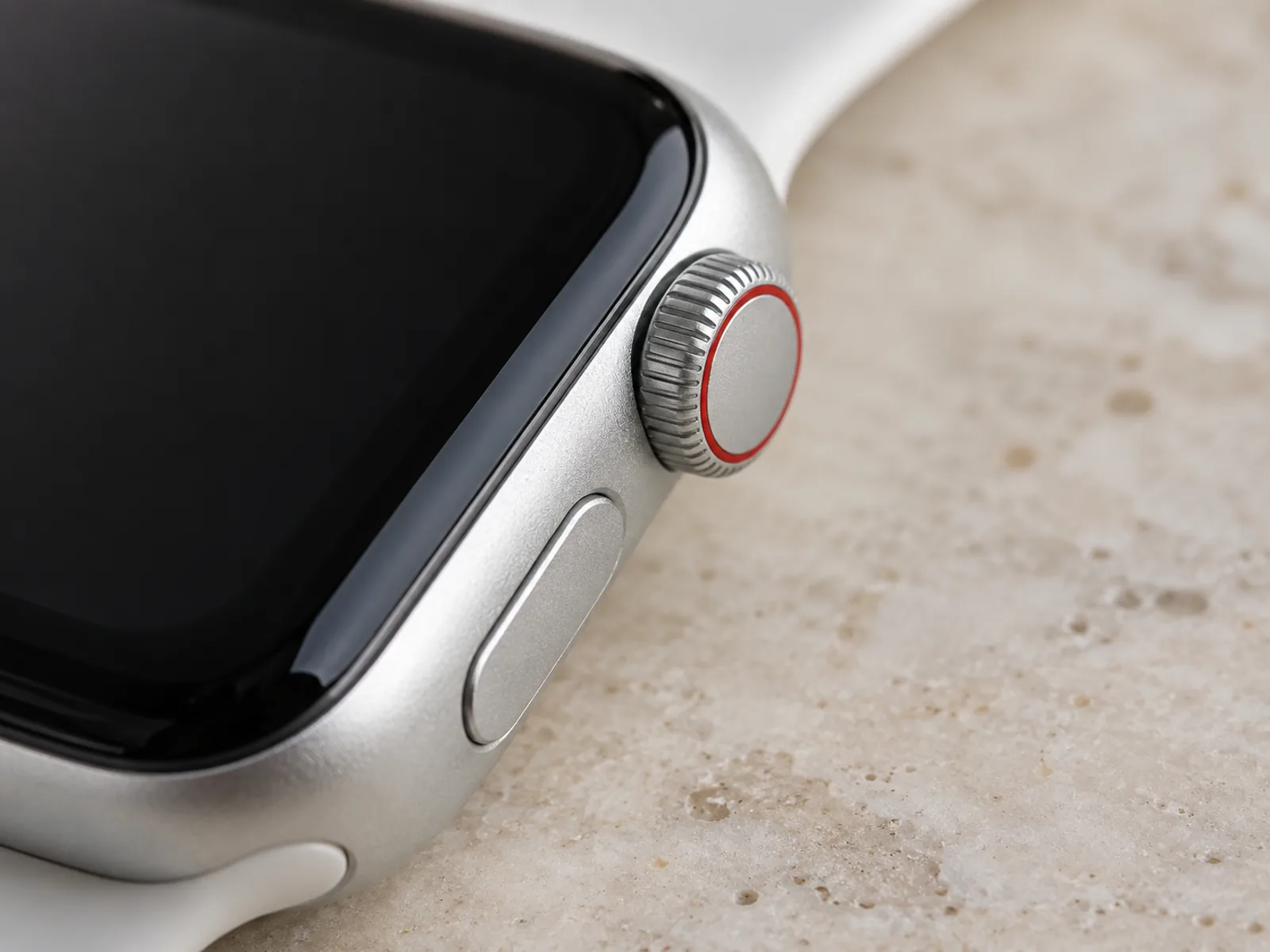 Close-up of a silver aluminum Apple Watch Digital Crown with a red ring on its face