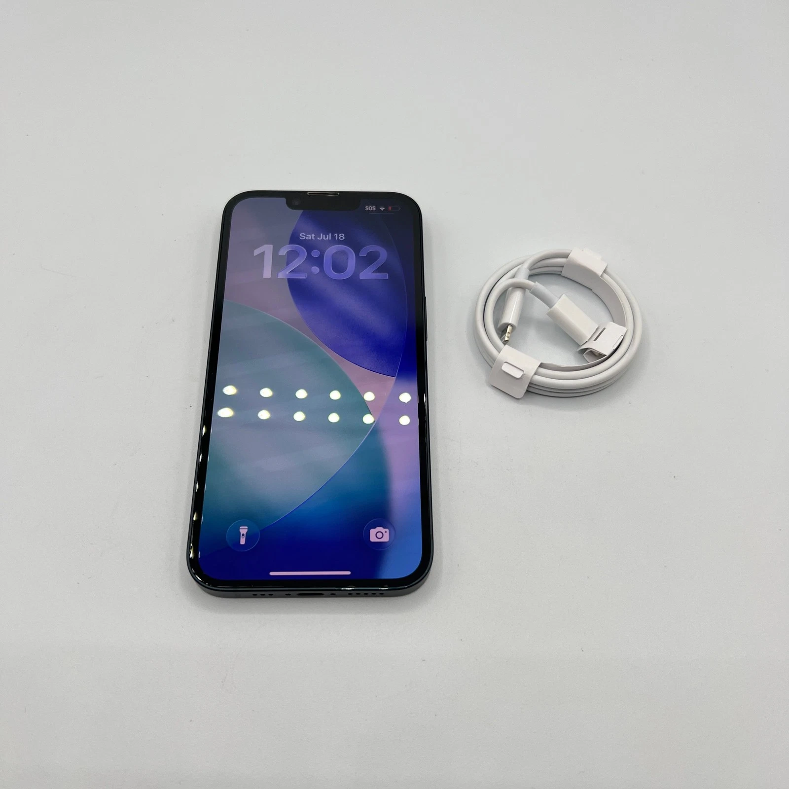 iPhone front, screen on, shown with charging cable